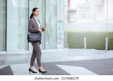 Asian business photo of beautiful girl in casual suite with smart phone,
asian woman with smartphone walking against street blurred building background. - Shutterstock ID 2174580179
