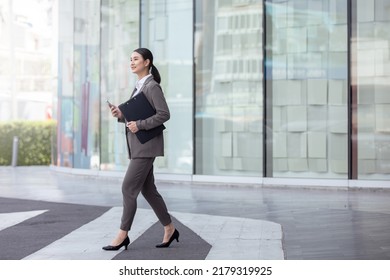 Asian business photo of beautiful girl in casual suite with smart phone,
asian woman with smartphone walking against street blurred building background. - Shutterstock ID 2179319925