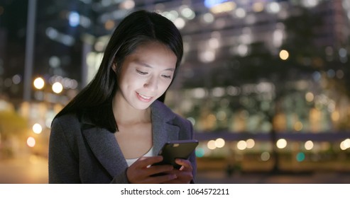Asian Business sending sms on smart phone at night  - Shutterstock ID 1064572211