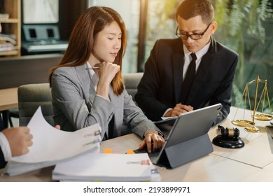 Asian Business Team And Lawyers Discussing Contract Papers Sitting At The Table. Concepts Of Law, Advice, Legal Services. At Modern Office