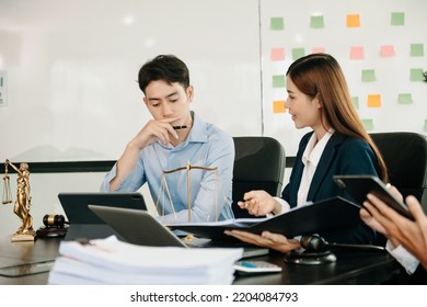 Asian Business Team And Lawyers Discussing Contract Papers Sitting At The Table. Concepts Of Law, Advice, Legal Services. At Modern Office