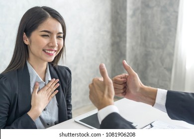 Asian business woman employee with smiling face for her success good job compliments from her boss and given a thumbs up  - business success concept 
