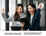 Asian business woman are excited business success with inspiration from their excellent financial results that are happy working in a modern office on a computer.