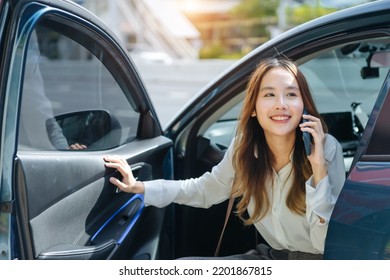 Asian Business Woman Gets Out Of Car And Holding Phone And Coffee Cup, Right-hand Drive, Left-hand Traffic, Business Lady, White Business Class Luxury