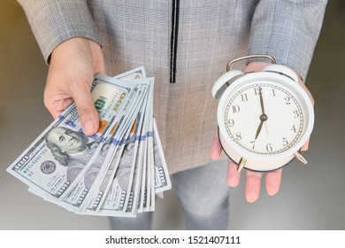 Asian business woman hold alarm clock and money in hand.  Business financial concept. Time is valuable as money. 