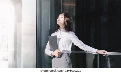 Asian Business Woman Looked Up With Eyes Closed Enjoying The Sun