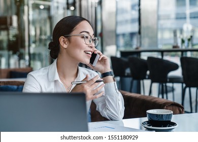 Asian Business Woman Making A Phone Call And Smiling Indoor