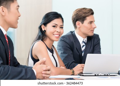 Asian Business Woman In Meeting Looking At Camera