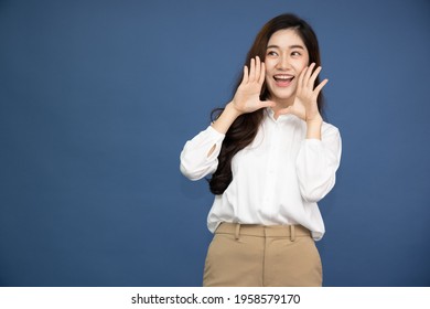 Asian Business Woman With Open Mouths Raising Hands Screaming Announcement Isolated On Blue Background