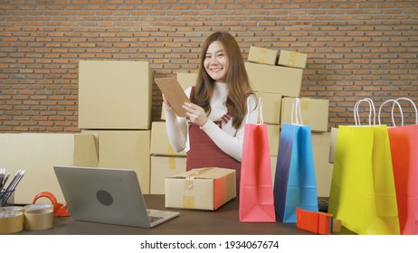 Asian Business Woman Packing Postal Parcel Packaging Carton Box Delivery, Working From Home With Laptop Computer, Selling Products Online Business. Shipping Service. People Lifestyle. SME Ecommerce