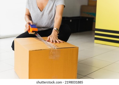 Asian Business Woman Packing Product Sealing Cardboard With Duct Tape