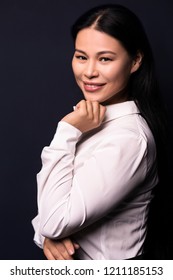 Asian Business Woman Posing On Camera. Wearing White Blouse. Isolated On Dark Background.