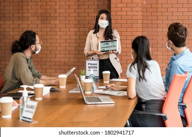 Asian Business Woman Present Her Work In Meeting For Brainstorm. They Wear Protective Face Mask In New Normal Office Preventing Coronavirus COVID-19 Spreading. 