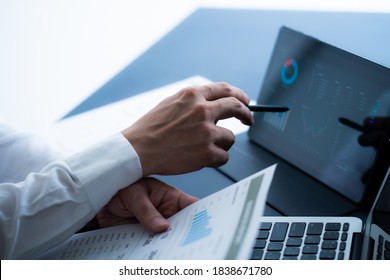 Asian Business Woman Reviewing Data In Financial Charts And Graphs With Tablet. Accounting