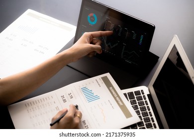 Asian business woman reviewing data in financial charts and graphs with tablet. Accounting - Shutterstock ID 2171375935