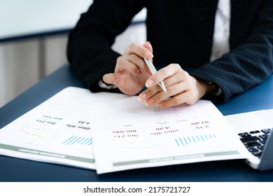 Asian Business Woman Reviewing Data In Financial Charts And Graphs. Accounting Concept