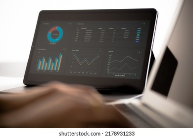 Asian Business Woman Reviewing Data In Financial Charts And Graphs With Tablet. Accounting