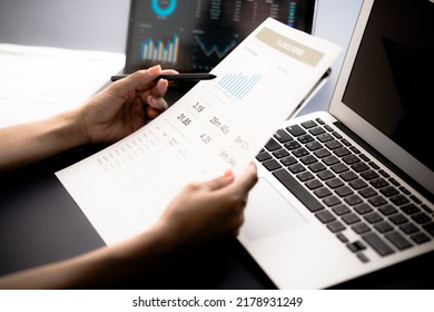 Asian Business Woman Reviewing Data In Financial Charts And Graphs With Tablet. Accounting