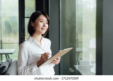 An Asian Business Woman With Short Hair Is Working