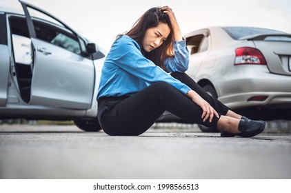 Asian Business Woman Sitting On The Floor, She Stressed And Wait For Notify Insurance Agents From The Accident Of A Car Collision, With Blur Two Care Background, To Accident Insurance Concept.