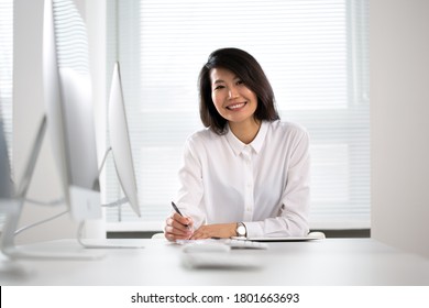 Asian Business Woman Smiling At Camera At Workplace In An Office