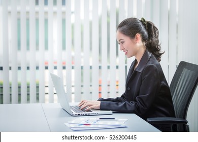 Asian Business Woman Are Smiling Working Typing In A Laptop On A Desk At Office
