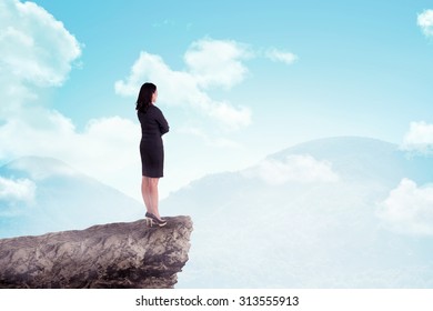 Asian Business Woman Standing On Top Of The Mountain. Business Success Concept