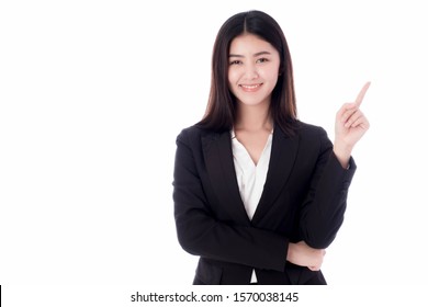 An Asian Business Woman Stands, Smiling, Looking At Her Face, Pointing Her Finger Up And Looking Straight On The White Background. There Is A Copyspace And Isolating.