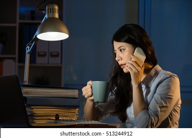 Asian Business Woman Talk On Smartphone Working Overtime Late Night. Indoors Office Background