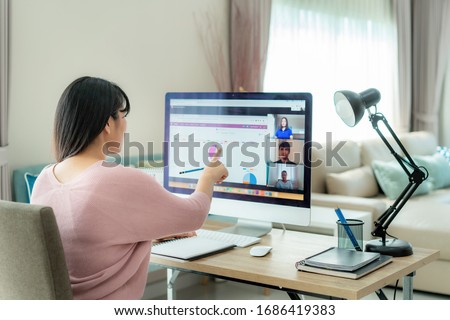 Asian business woman talking to her colleagues about plan in video conference. Multiethnic business team using computer for a online meeting in video call. Group of people smart working from home.