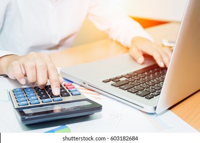 Asian Business Woman Using A Calculator To Calculate The Numbers