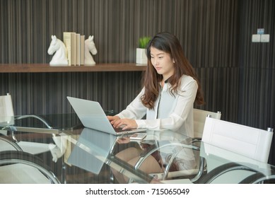 An Asian Business Woman Using Laptop In Office