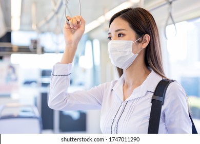 Asian Business Woman Wear Surgical Mask Face To Protect Herself While Commuting In The Metro Or Train