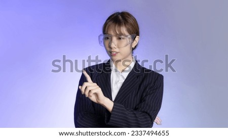 Asian business woman wearing vr glasses posing finger press and touching on virtual reality screen on purple background. Businesswoman wearing AR glasses.