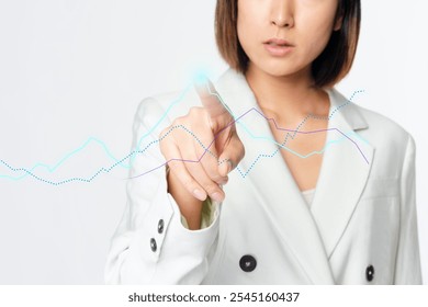 Asian business woman in a white blazer pointing directly at the camera. The business woman touching graph on the screen white plain background with copy space. Digital interface, technology concept. - Powered by Shutterstock