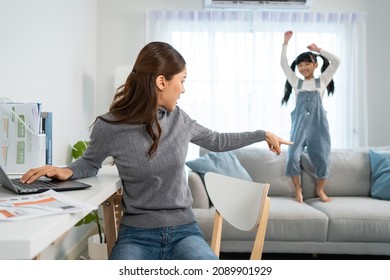 Asian Business Woman Work At Home With Young Kid Daughter Play Around. Attractive Beautiful Mother Loss Concentration On Job In Laptop Computer And Feel Frustrated From Children Making Noise In House.