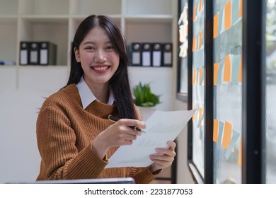 Asian Business woman working at home office and analyze financial report document. Accounting and Finance concept - Powered by Shutterstock