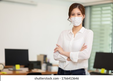 Asian Business Women Leader Wearing Mask Protection Virus Standing Smile Cross Arm And Confidence At Co-Working Space Due Covid-19 Flu Pandemic,Health Care And Business Startup Concept 