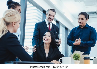 Asian business working woman in meeting room receiving compliments and congratulations for colleague with various nationalities by giving her clap. Business woman have praised by colleagues in team.