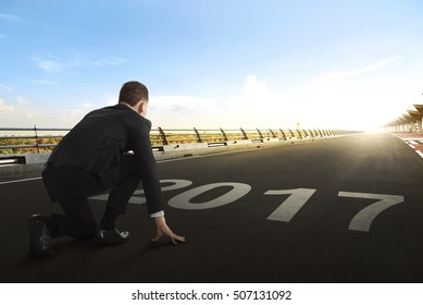 Asian businessman with 2017 numbers as starting line waiting for the start in running track