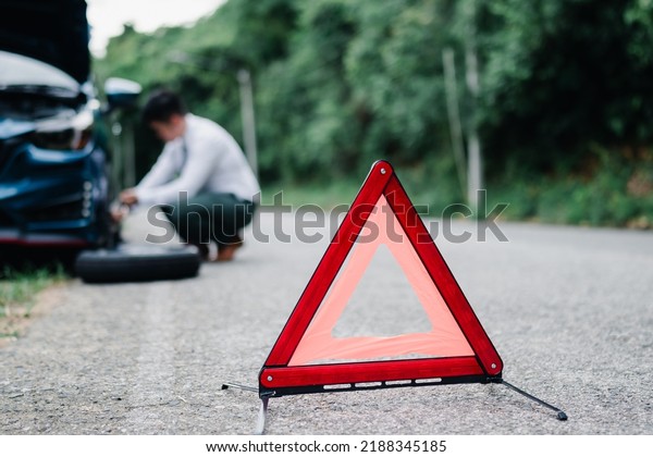 Asian businessman broken\
car engine breakdown his calling insurance stressed emotion\
problem, Accident emergency on the mountain road outdoor late for\
work concept.