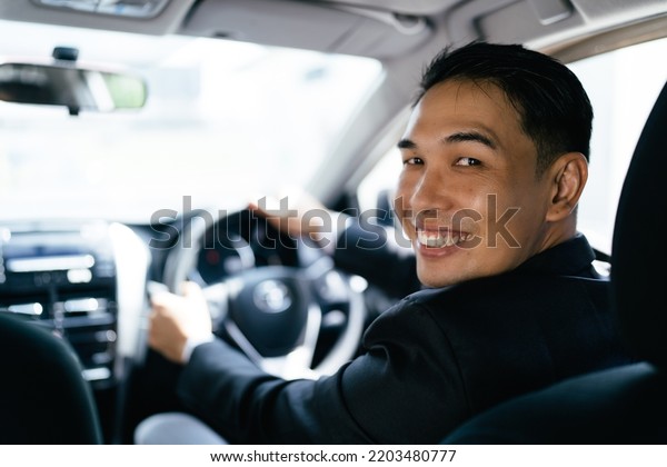 Asian businessman driving car and smile, car\
insurance concept.
