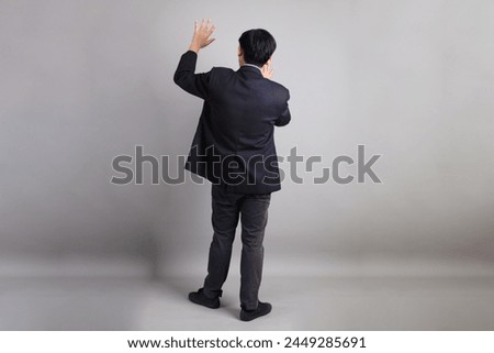 The Asian Businessman with formal dressed with gesture of stop, forbid, refusing on the gray background.