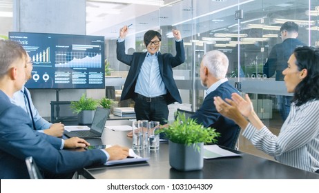 Asiatischer Geschäftsmann gibt ihren Geschäftspartnern Bericht/ Präsentation. Jeder freut sich und applaudiert und gibt High Five, die sein Projekt billigen.