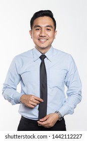 Asian businessman holding his neck tie