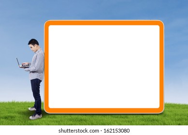 Asian businessman with a laptop standing beside the blank board - Shutterstock ID 162153080