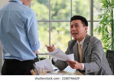 Asian Businessman Manager In Suit Holding Paperwork And Strong Talking For Young Employee With Anger And Serious Gesture Look Like He Comments As Disagree Or Unacceptable For His Project Work