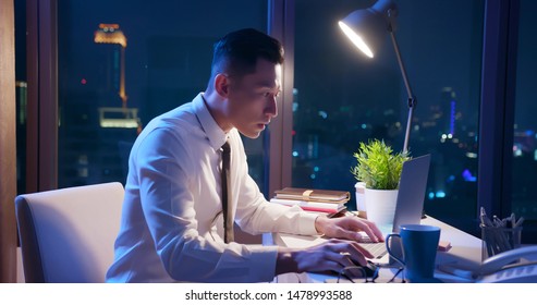 Asian Businessman Overtime Work Alone In The Office