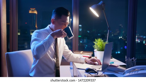 asian businessman overtime work and drink tea or coffee in the office - Powered by Shutterstock