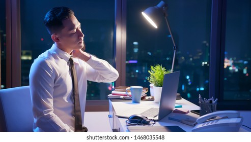 Asian Businessman Overtime Work And Feel Neck Pain In The Office